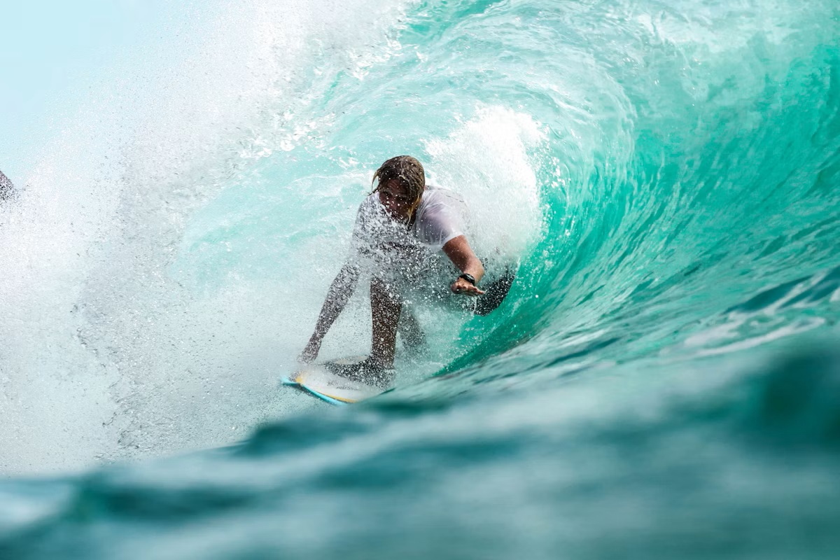 Surfer riding a blue ocean wave